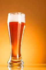 Glass of beer on a yellow background