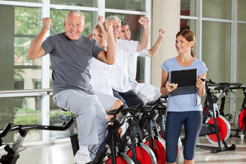 Jubelnde Senioren mit Fitnesstrainerin