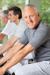 Senioren im Fitnesscenter fahren Rad