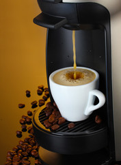 Espresso machine pouring coffee in cup on brown background