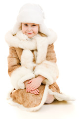 A girl in a fur coat and hat smiling on white background.