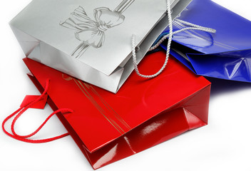 Red, blue and gray gift bags on a white background.