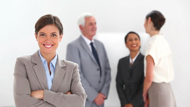 Businesswoman posing with colleagues talking 