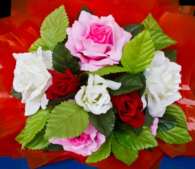Bouquet of artificial roses with a red background