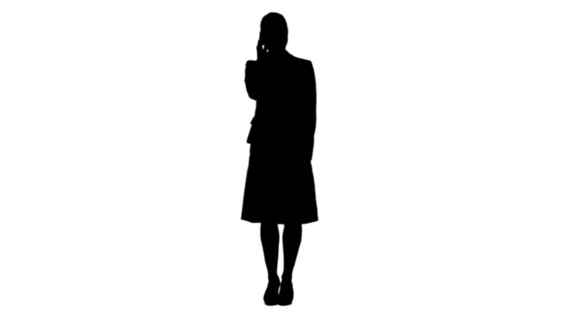 Silhouette of a standing woman talking on her mobile phone