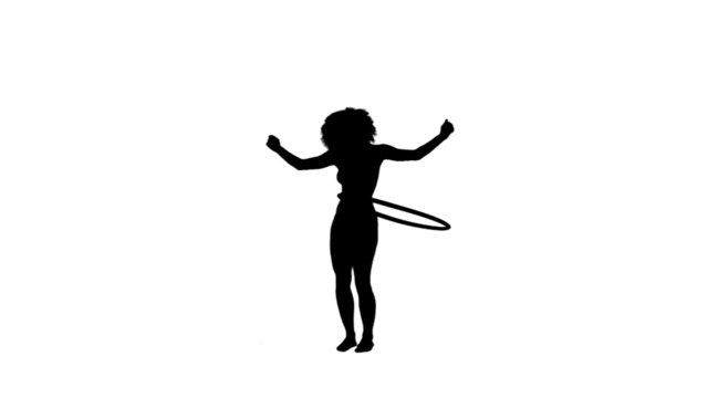 Silhouette of a woman using a hula hoop
