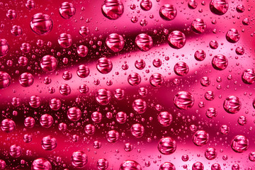 Water drops on red glass surface