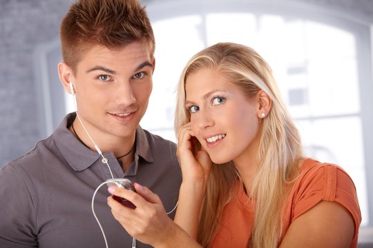 Happy couple listening to music via earphones