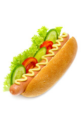 hot dog with cucumbers, tomatoes, lettuce, and mustard on white