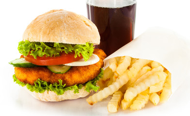 Big hamburger, French fries and vegetables on white background
