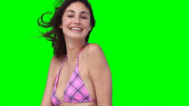 A woman smiles while hopping up and down