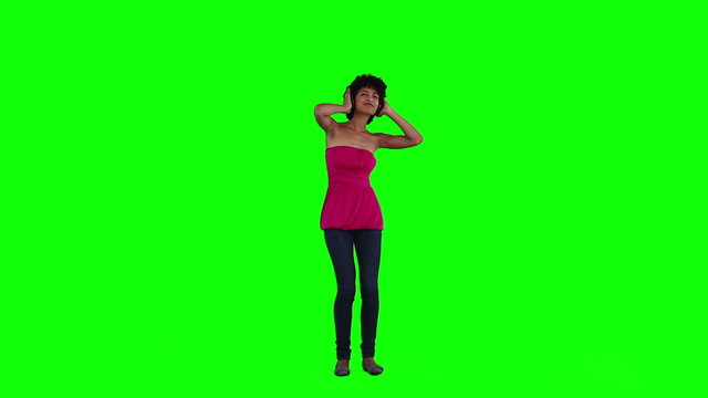A woman with headphones is dancing
