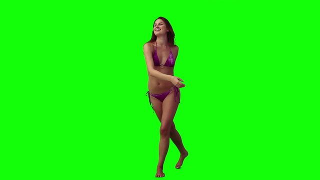 A woman wearing a bikini is throwing a frisbee