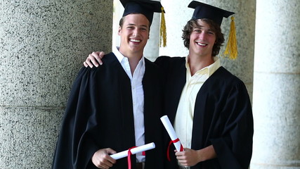 Smiling boys holding their diplomas