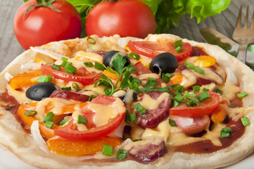 Fototapeta na wymiar pizza with tomatoes, cheese, black olives and peppers.