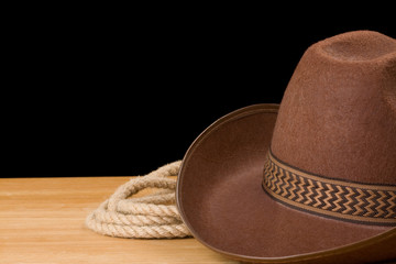 brown cowboy hat and rope isolated on black