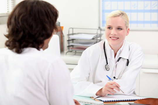 Smiling female doctor talking to a male patient