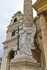Fototapeta na wymiar Posąg anioła z krzyżem przed Karlskirche (St Charles C