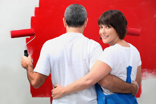 Couple painting wall in red