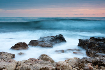 Beautiful rocky sea beach at the sunset