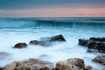 Beautiful rocky sea beach at the sunset