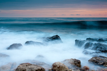 Beautiful rocky sea beach at the sunset