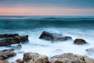Obraz premium Beautiful rocky sea beach at the sunset