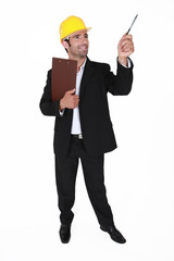 businessman wearing helmet pointing with a pen