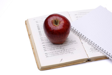 A red apple on a book and a notebook, isolated on white