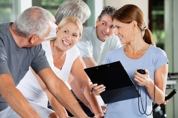 Lachende Senioren mit Fitnesstrainer