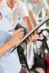 Fitnesstrainerin kontrolliert Checkliste