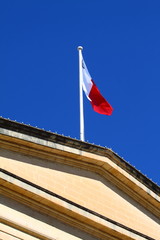 Flag of Malta against blue sky during wind