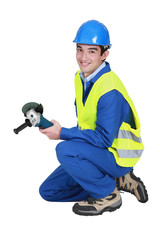 A male construction worker with a grinder.