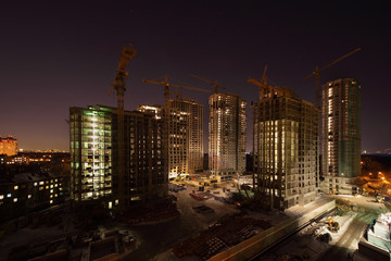 Fototapeta na wymiar Seven high buildings under construction with cranes