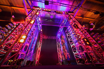 Multi-colored illuminated way to boxing ring inside fight club;