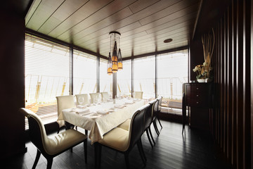 table with white tablecloth and serving and white chairs