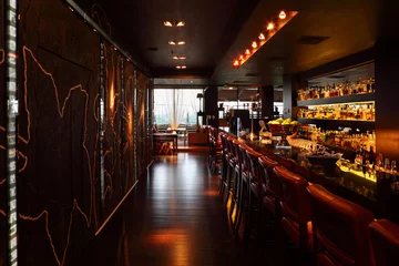 Papier Peint photo Restaurant Comptoir de bar avec des chaises hautes rouges dans un restaurant vide