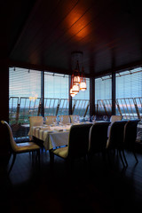 table with white tablecloth and serving and ten white chairs