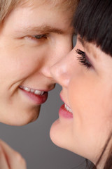 Obraz premium Young happy man and woman smile close up on gray background