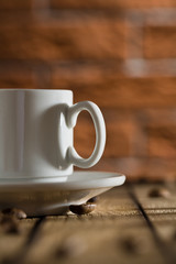 white coffee cup on a background of a brick wall