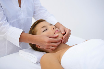Woman being treated to face massage