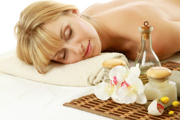 Obraz na płótnie Canvas A woman enjoying spa treatment, lying isolated on white