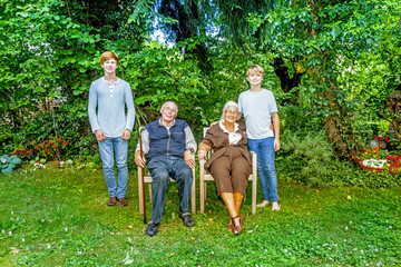 Fototapeta premium extended family group posing in the garden with grandparents