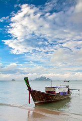 Seascape with exotic island and long tail boat in Thailand