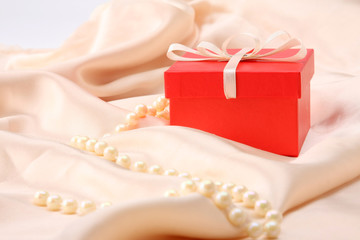 A present box on a pink material with beads