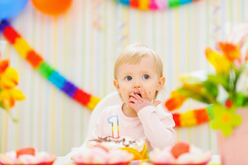 Kid eating first birthday cake