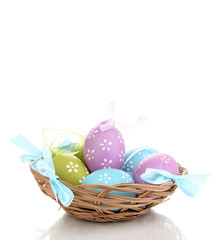 Colorful easter eggs in basket isolated on white