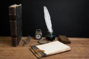 Quill, book, magnifying glass, notepad, clock, spectacles