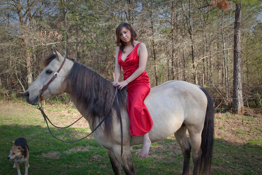 woman in red dress riding a horse bareback