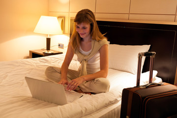 Young woman using laptop in hotel